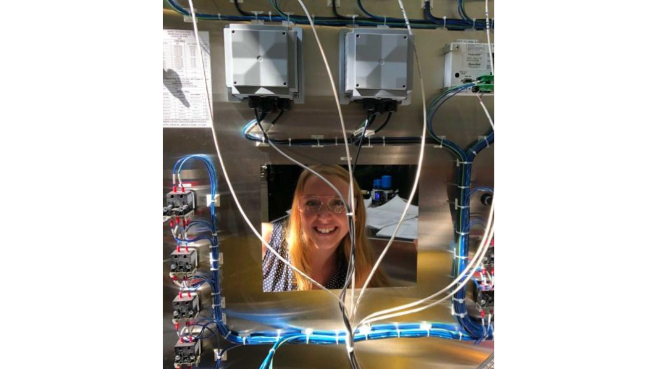 Picture of Cassy Gardner surrounded by machine parts