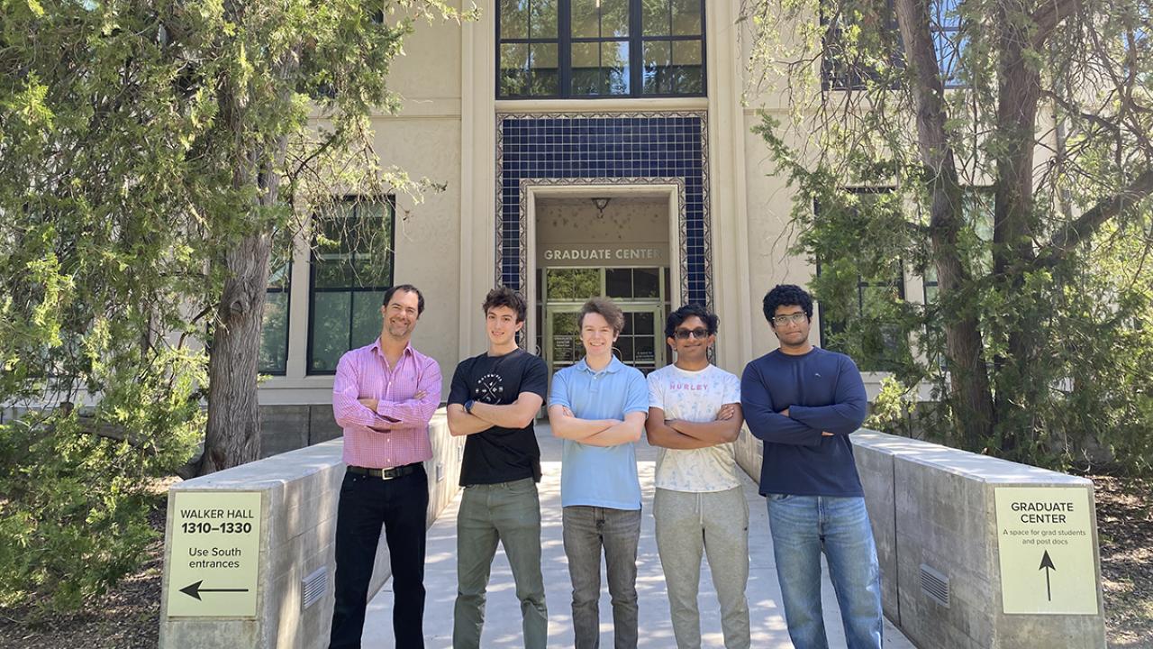 Five people stand outside of an engineering building on the UC Davis campus